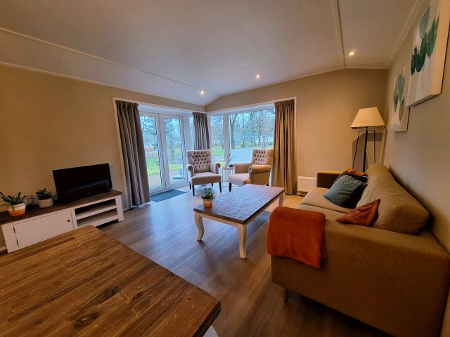 Ruime woonkamer van Huisje H03 met huiselijke zithoek